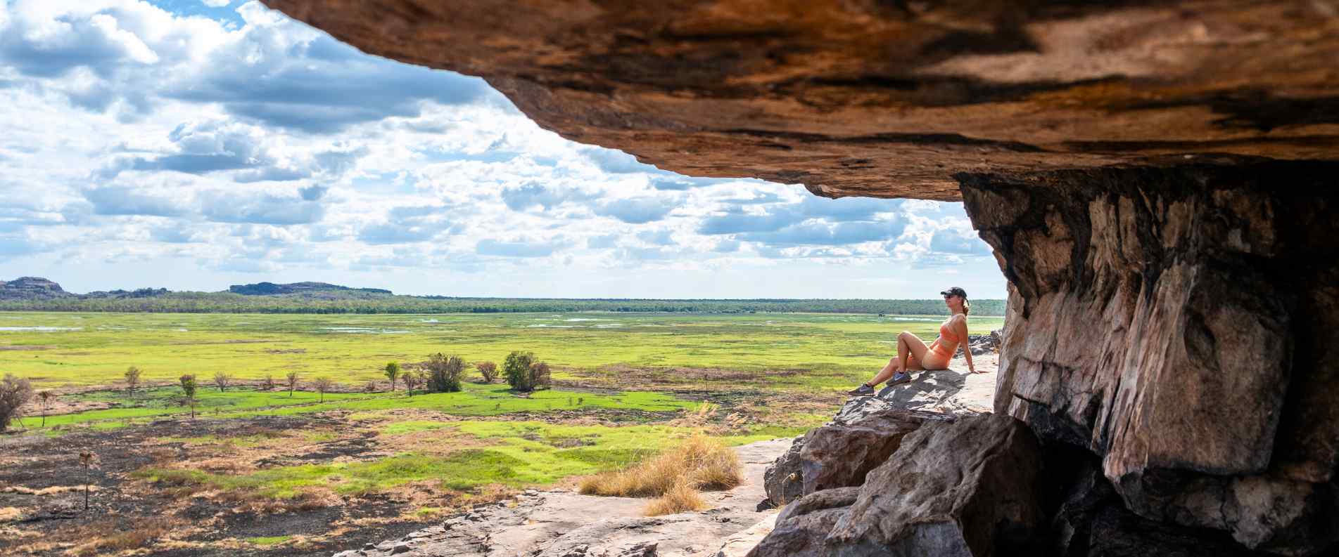 woman laying on rock overlooking wetlands